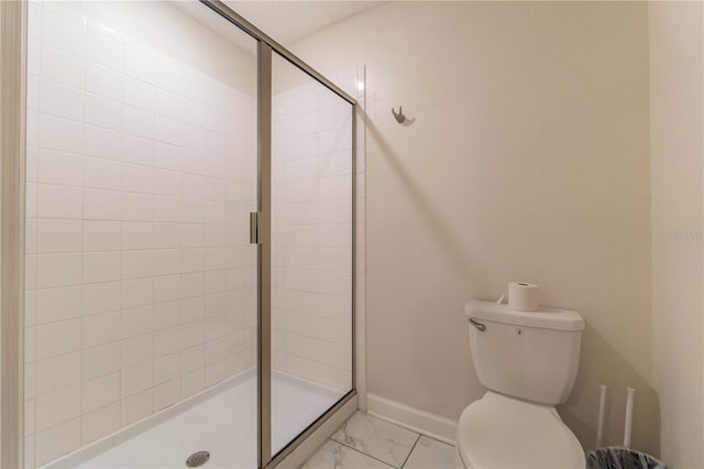 bathroom featuring toilet and a shower with door