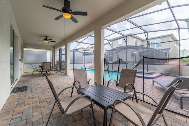 view of patio with glass enclosure, ceiling fan, and a swimming pool with hot tub