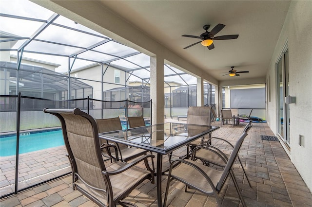 view of patio with ceiling fan and glass enclosure