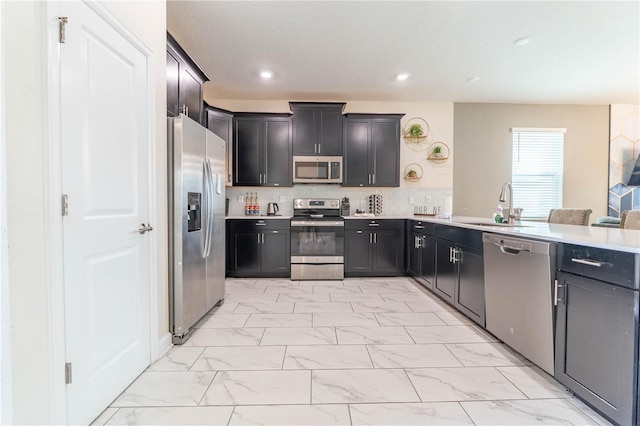 kitchen with sink, appliances with stainless steel finishes, and tasteful backsplash