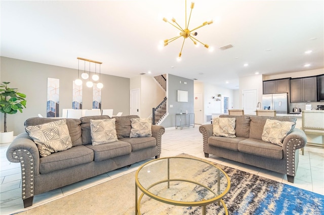 tiled living room with a notable chandelier