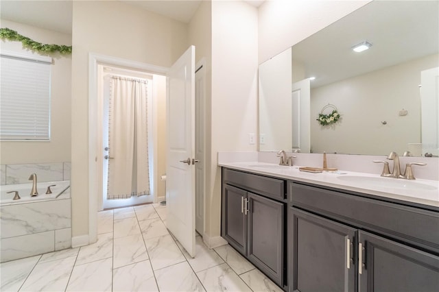 bathroom featuring vanity and tiled tub