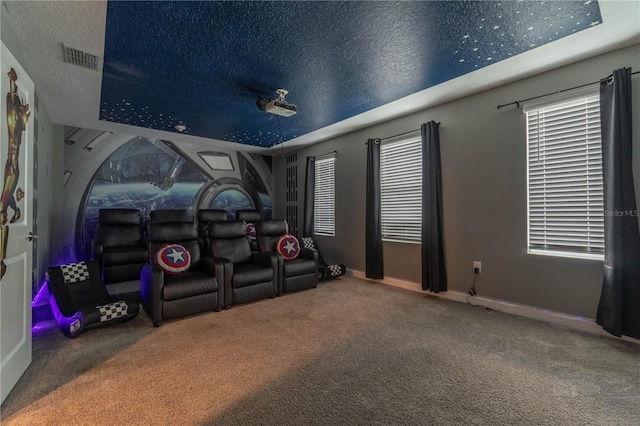 carpeted cinema room with a textured ceiling