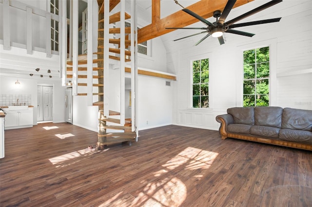 unfurnished living room featuring ceiling fan, sink, high vaulted ceiling, beamed ceiling, and dark hardwood / wood-style floors