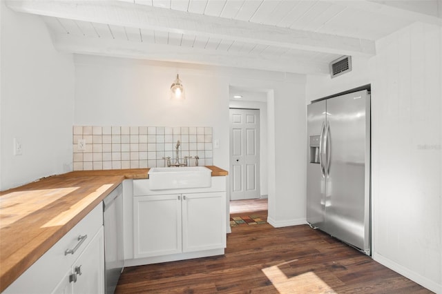 kitchen featuring appliances with stainless steel finishes, sink, pendant lighting, white cabinets, and butcher block counters