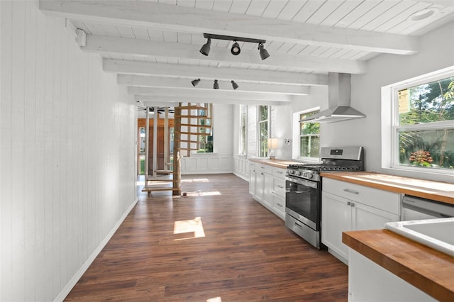 kitchen featuring track lighting, stainless steel range with gas cooktop, white cabinetry, butcher block counters, and extractor fan