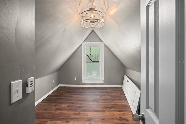 additional living space with dark hardwood / wood-style floors, lofted ceiling, and an inviting chandelier