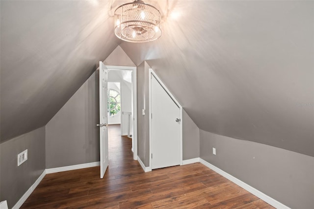 additional living space featuring a notable chandelier, dark hardwood / wood-style floors, and lofted ceiling