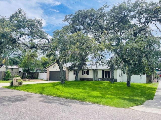 ranch-style home featuring a garage and a front lawn