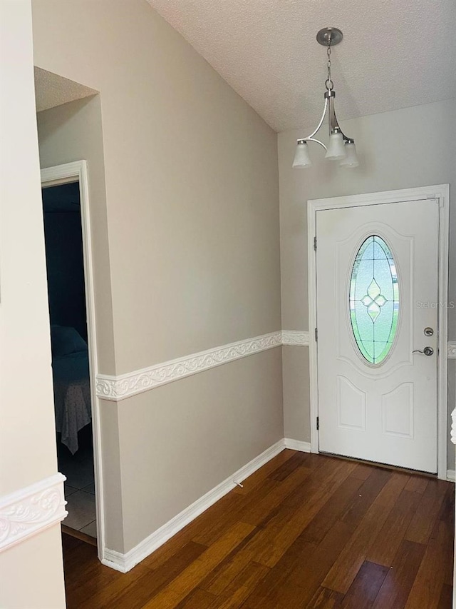 tiled foyer with a notable chandelier and a textured ceiling