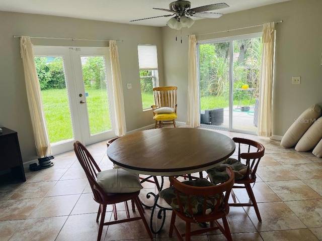 tiled dining room featuring ceiling fan and french doors