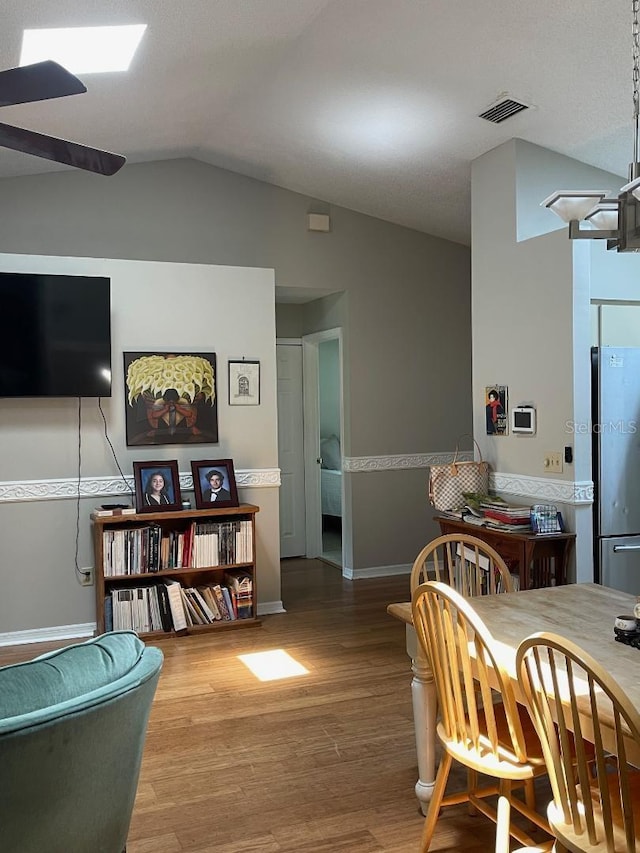 dining room featuring lofted ceiling, wood-type flooring, and ceiling fan