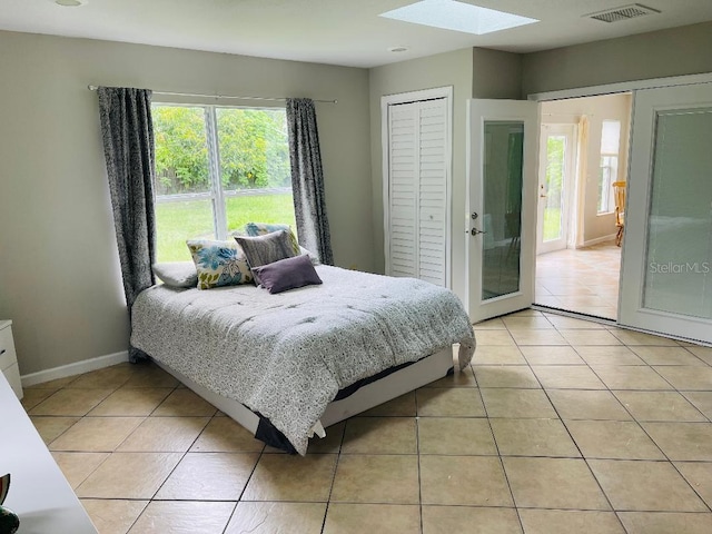 tiled bedroom with a closet and a skylight