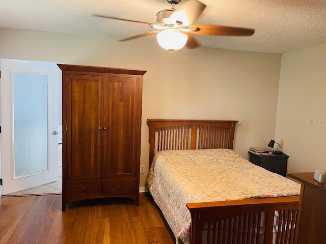 bedroom with dark wood-type flooring, ceiling fan, and a textured ceiling