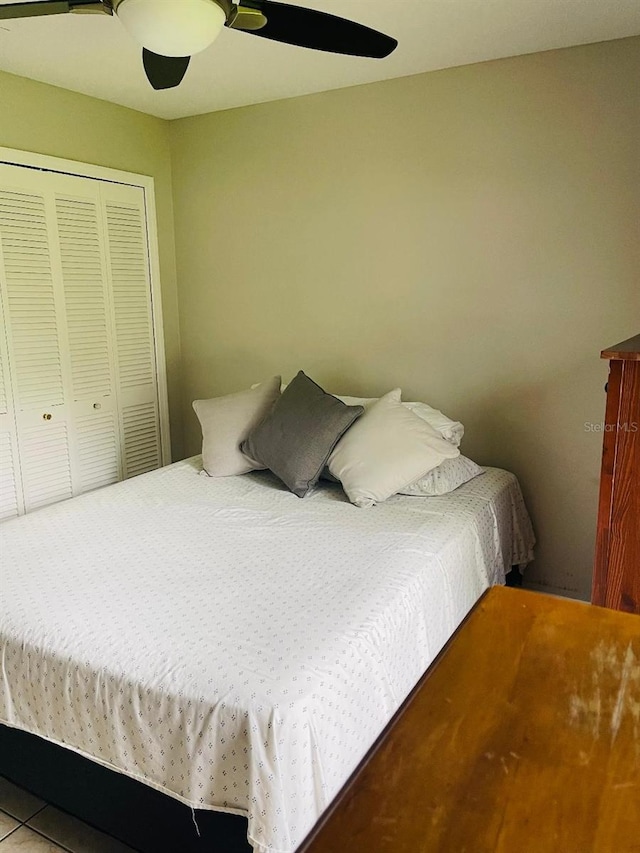 bedroom featuring a closet, ceiling fan, and tile floors