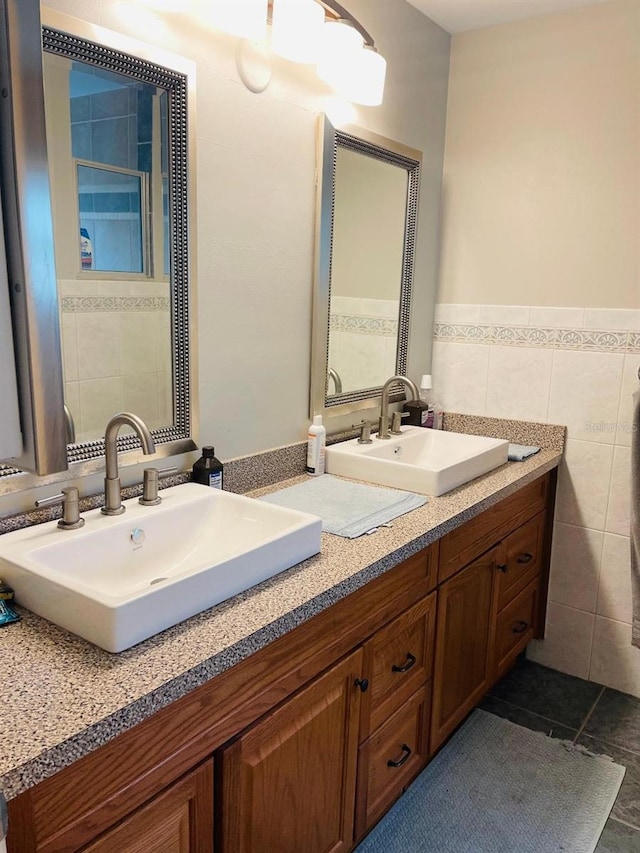 bathroom with dual vanity, tile walls, and tile flooring