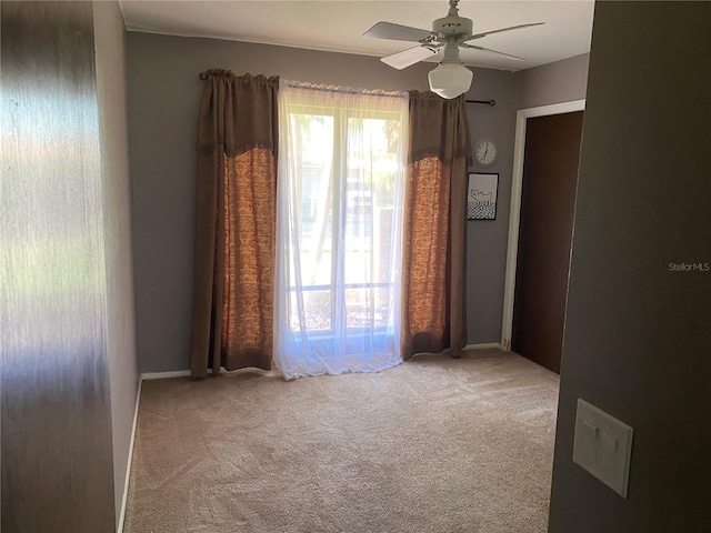 unfurnished room featuring light colored carpet and ceiling fan