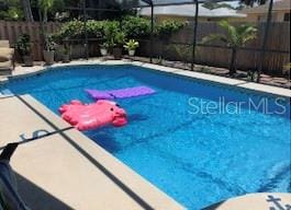 view of pool with glass enclosure