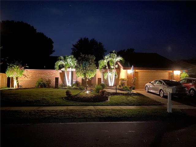 view of front of house featuring a garage and a lawn