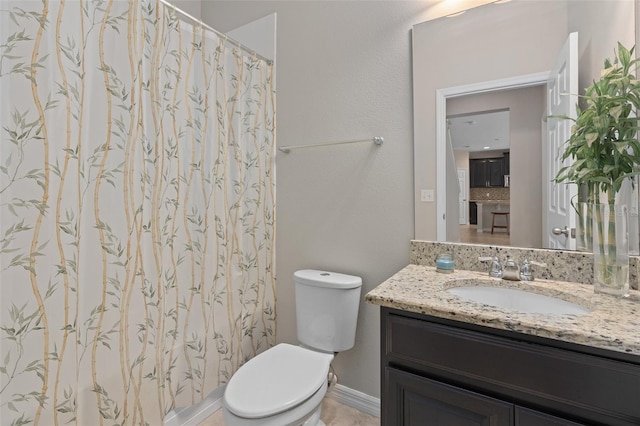 bathroom featuring toilet, vanity, and tasteful backsplash