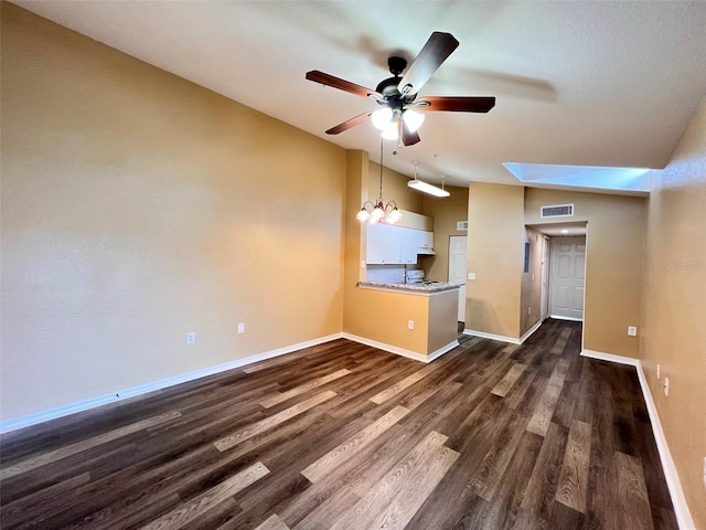 unfurnished living room featuring a skylight, dark wood-type flooring, and ceiling fan