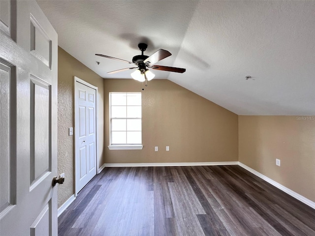 bonus room featuring wood-type flooring, vaulted ceiling, a textured ceiling, and ceiling fan