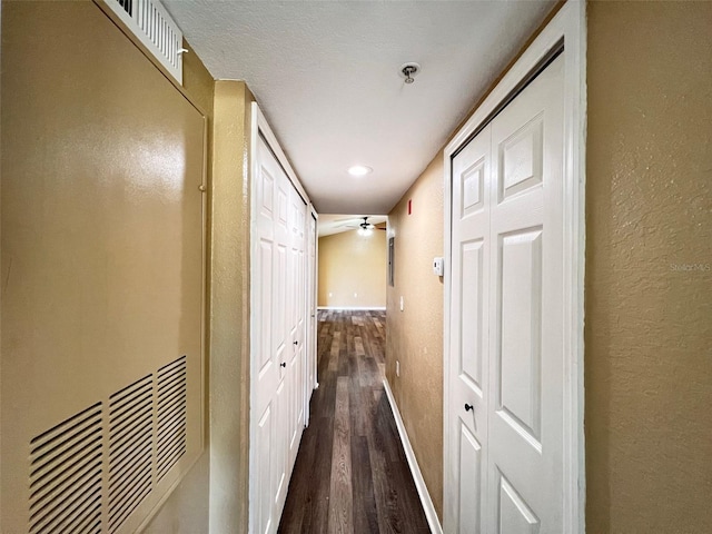 corridor with dark wood-type flooring and a textured ceiling