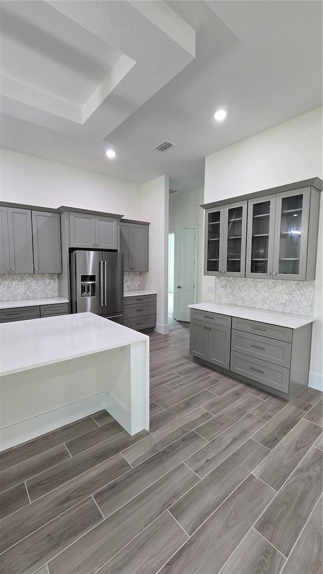 kitchen with decorative backsplash, high quality fridge, and gray cabinetry