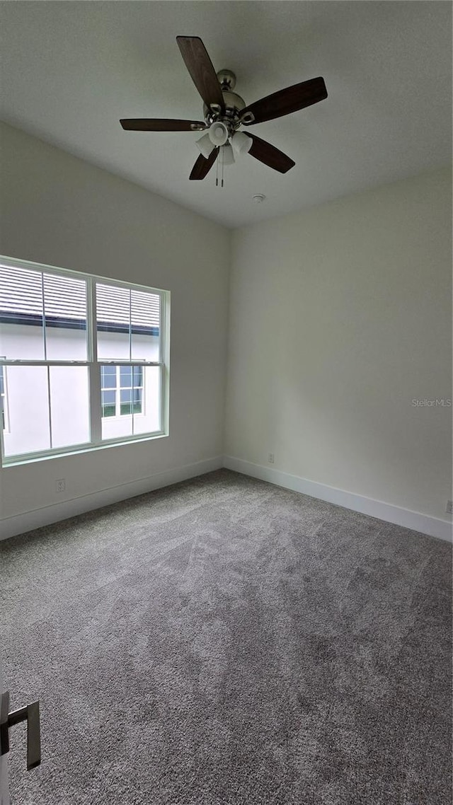 unfurnished room featuring ceiling fan and carpet floors