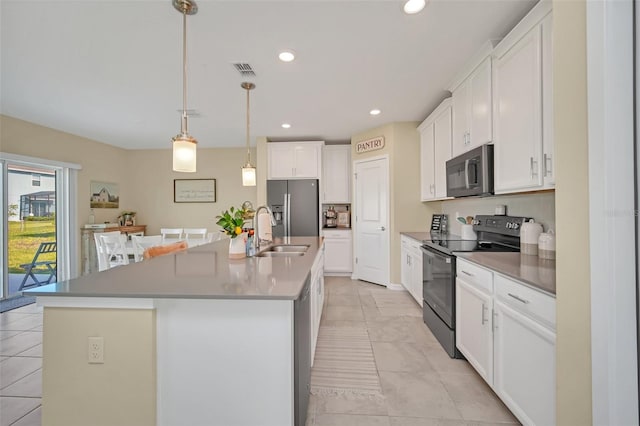 kitchen featuring stainless steel appliances, a kitchen island with sink, white cabinetry, sink, and light tile floors