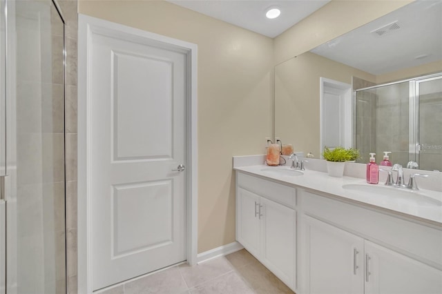 bathroom featuring tile floors, walk in shower, oversized vanity, and dual sinks