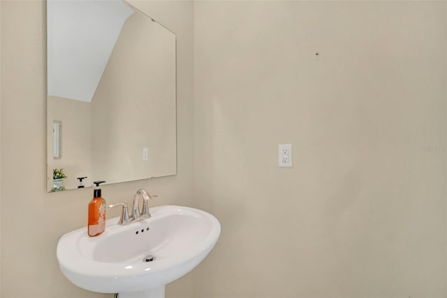 bathroom featuring vaulted ceiling and sink