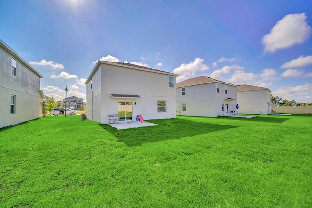 rear view of property featuring a lawn and a patio