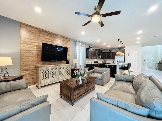 tiled living room featuring wooden walls and ceiling fan