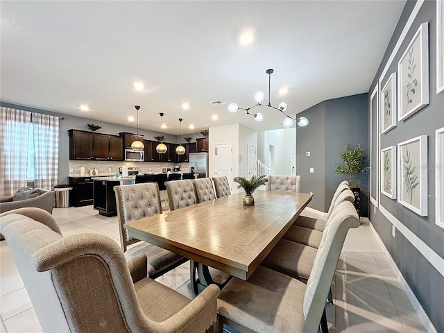 tiled dining space with an inviting chandelier