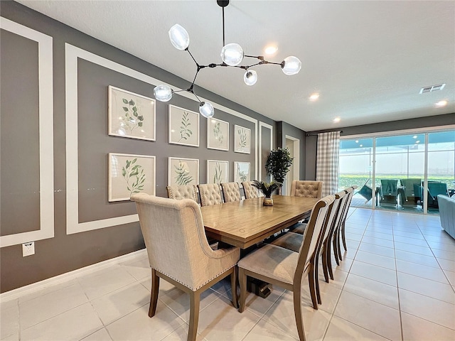 dining area featuring light tile patterned flooring and a notable chandelier