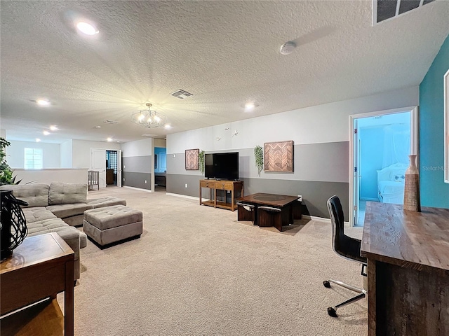 living room with light carpet, a textured ceiling, and an inviting chandelier