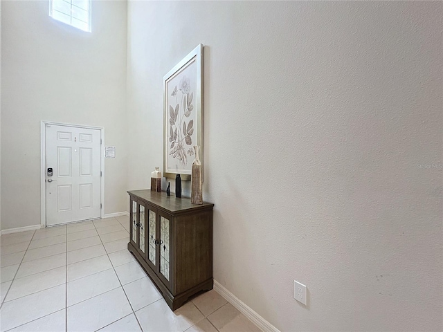 entrance foyer with light tile patterned floors and a high ceiling