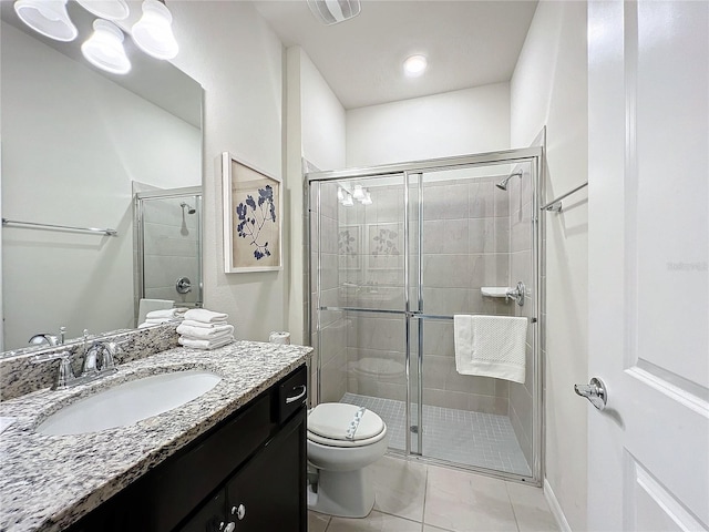 bathroom featuring tile patterned flooring, vanity, toilet, and walk in shower