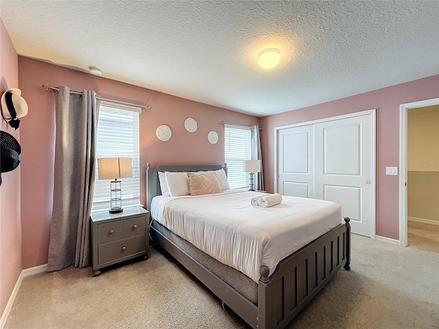 bedroom with a closet, light colored carpet, and multiple windows