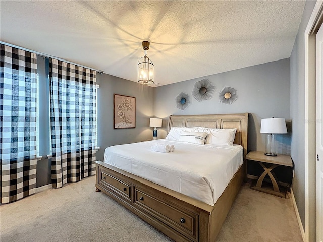 bedroom featuring light carpet and a textured ceiling