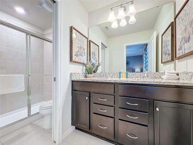 bathroom with tile patterned floors, vanity, an enclosed shower, and toilet