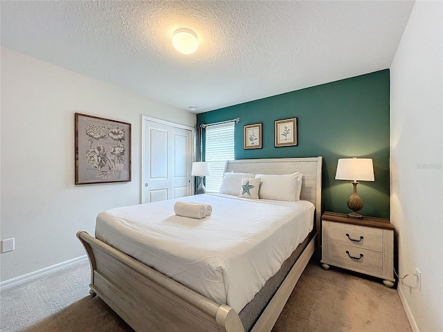 carpeted bedroom with a closet and a textured ceiling