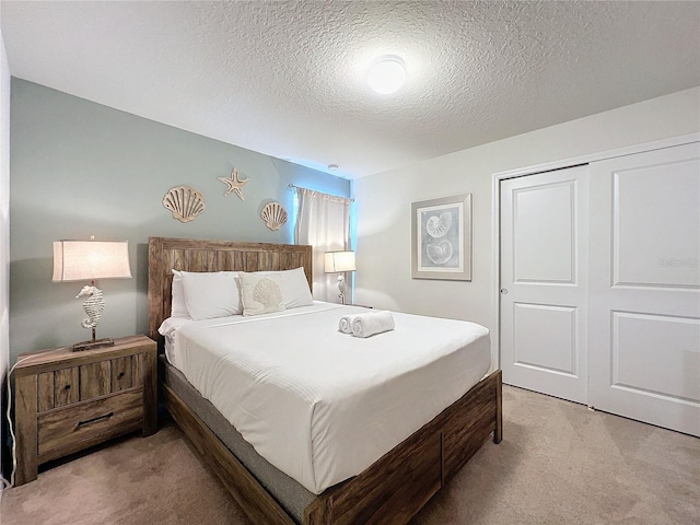 bedroom featuring carpet flooring, a closet, and a textured ceiling