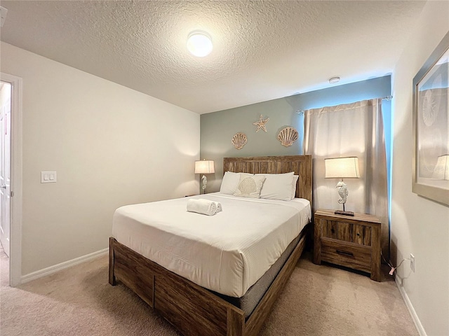 bedroom featuring a textured ceiling and light carpet