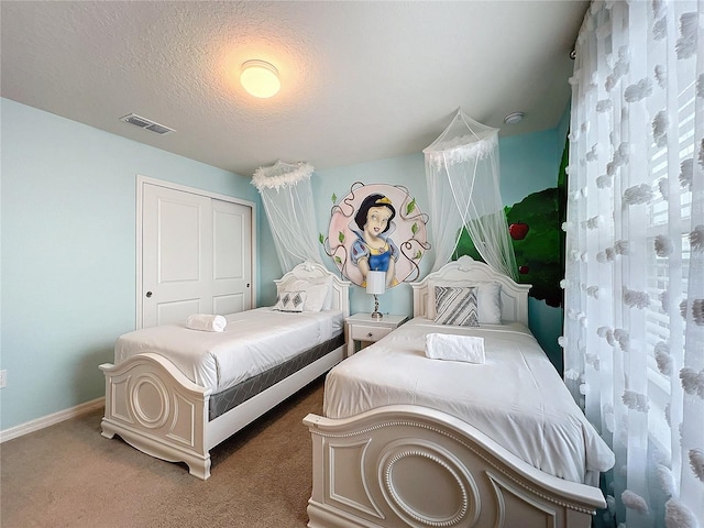 bedroom with a closet, dark carpet, and a textured ceiling