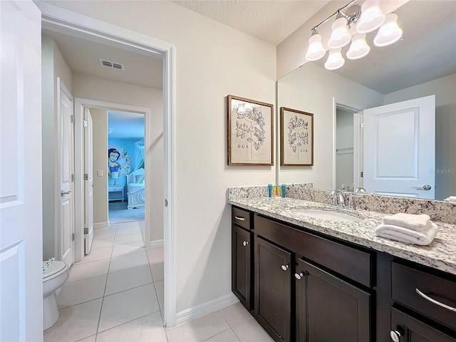 bathroom featuring tile patterned floors, vanity, toilet, and a textured ceiling