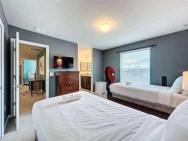 bedroom with carpet flooring, a textured ceiling, and ensuite bath