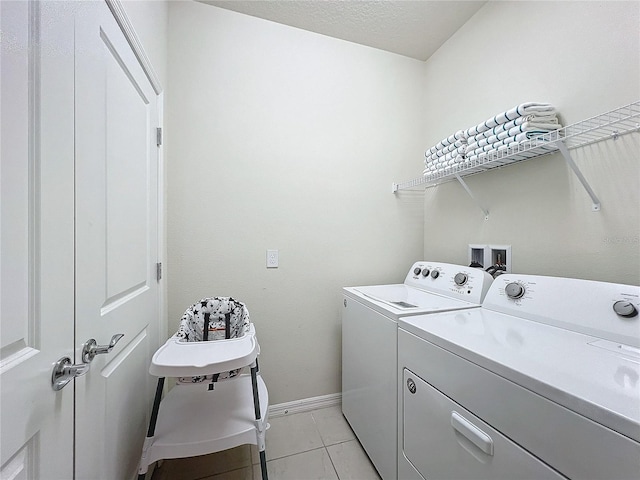 laundry room with light tile patterned flooring, separate washer and dryer, and a textured ceiling