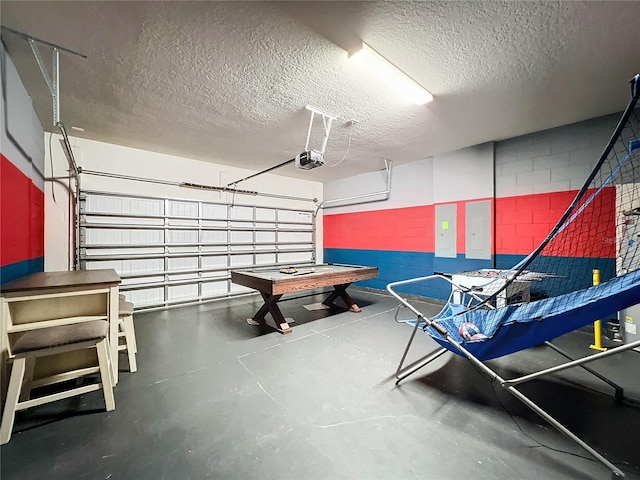 rec room with a textured ceiling, electric panel, and concrete floors